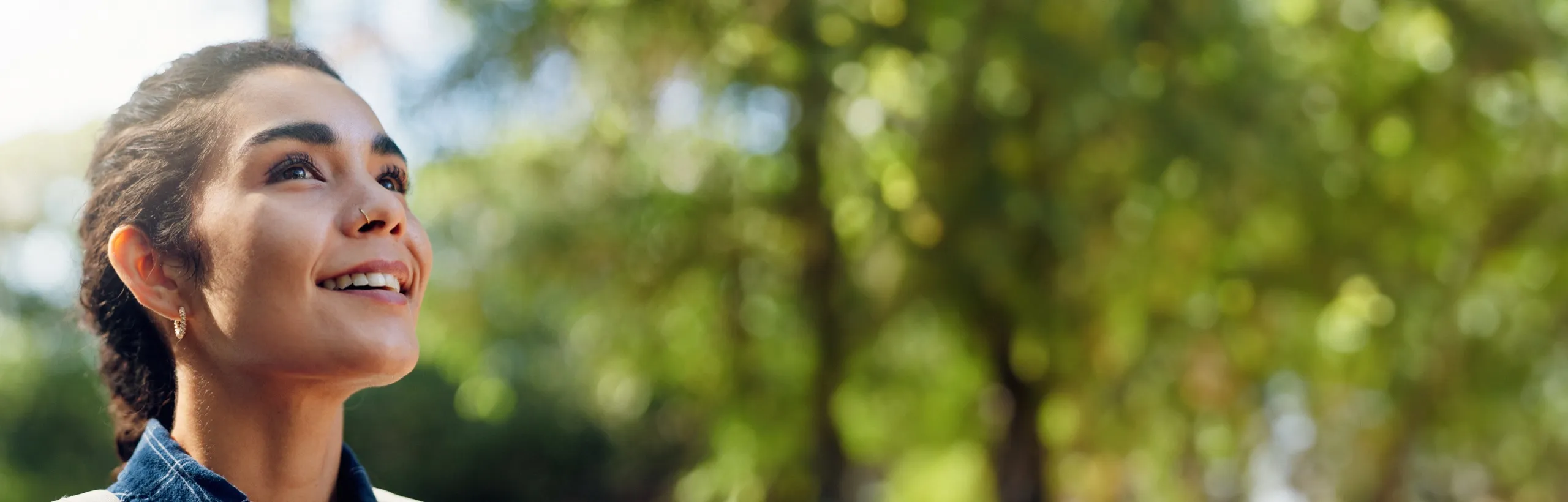 Woman hiking outdoors looking up with optimism