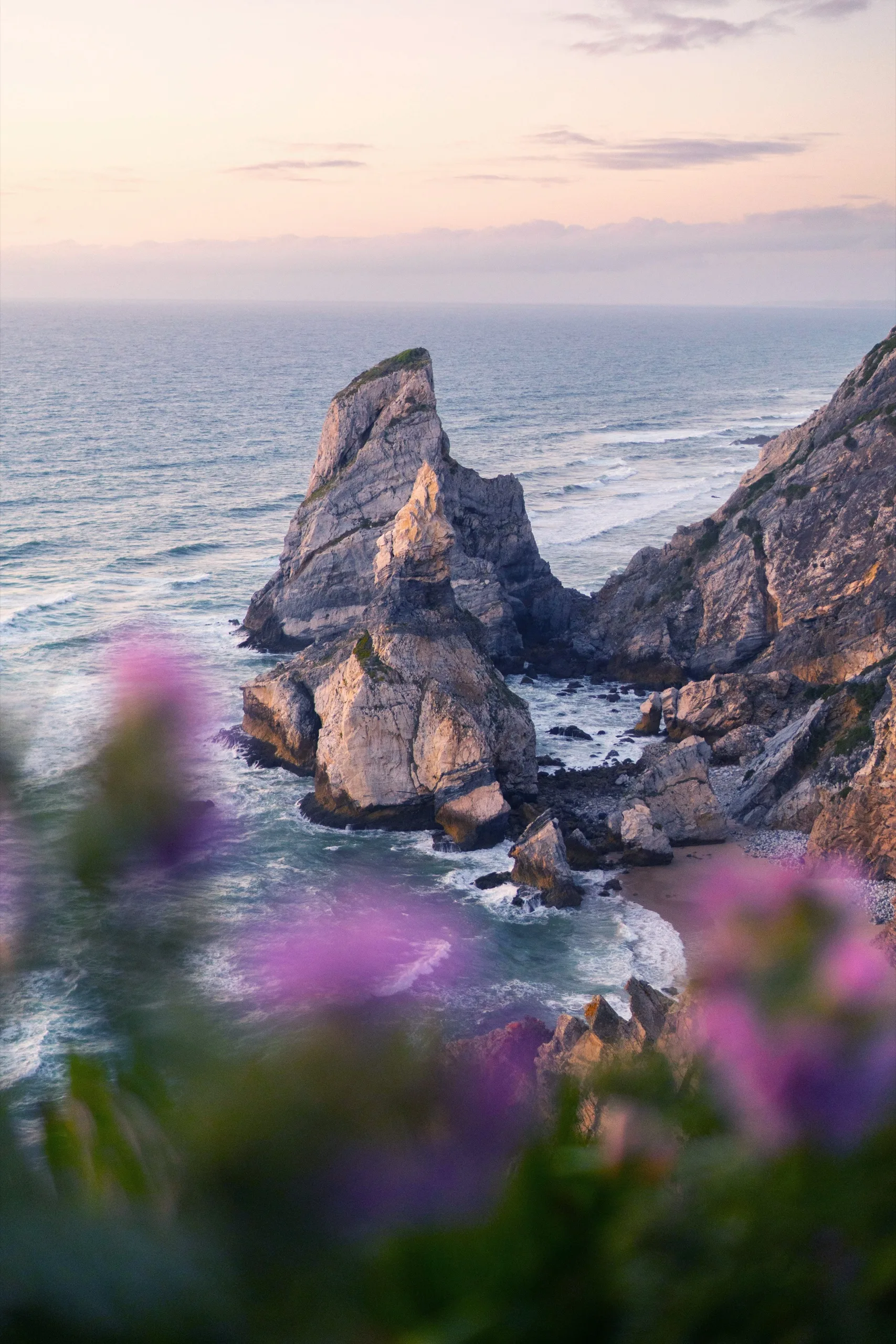 Sea cliffs at dusk, waves breaking against rock formations